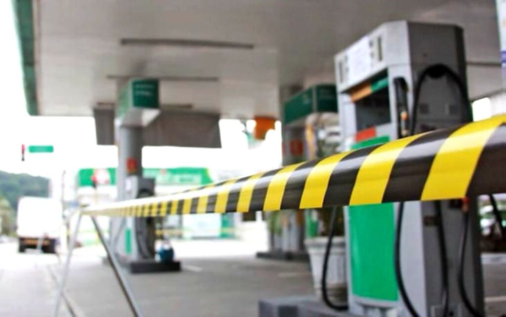 Bombas de combustível bloqueadas em posto de gasolina, indicando falta de gasolina e diesel para abastecimento.